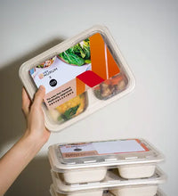 hand lifting meal box against white background