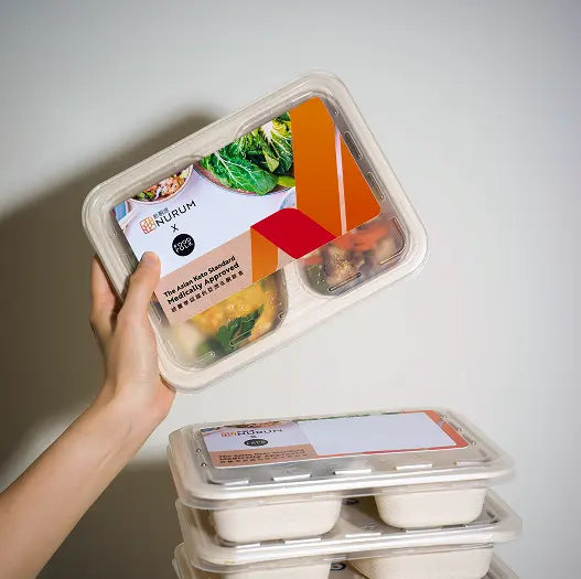 Prepared meals in individual compartments on a beige background